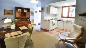 A compact kitchen with white cabinets, a built-in oven, and a window. - Villa a Palafrugell con Spiaggia di Mare (Palafrugell)