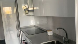 A modern kitchen with stainless steel appliances, a built-in oven, and a sink with a faucet. - Belvilla by OYO Apartamento Port Avenue (Marbella)