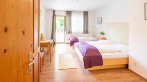 Una habitación de hotel con dos camas, un escritorio y un armario.