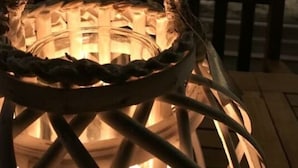 A woven lantern hanging in a room with a fireplace in the background. - Majestic Apartment in Trarego-viggiona (Trarego Viggiona)