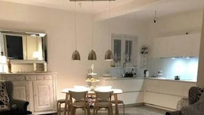 A living room with a dining area, a kitchen, and a large rug. - Majestic Apartment in Trarego-viggiona (Trarego Viggiona)