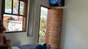 A bedroom with a bed, a television on the wall, and a window. - Pousada Sempre Viva  (São João Batista do Glória)