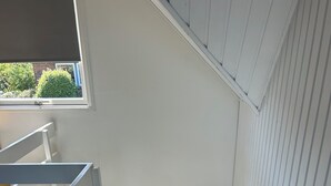 A staircase with white railings and a framed picture on the wall.