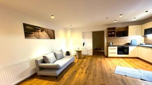 A modern apartment with a living area, kitchen, and dining space.