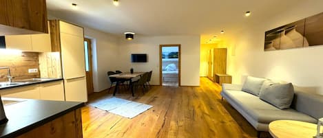 Un interno moderno con cucina, zona pranzo e angolo living.