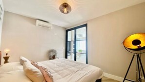 A bedroom with a bed, a floor lamp, and a window. - Beautiful Holiday Home Near sea in Katwijk (Katwijk Aan Zee)