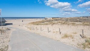 A coastal pathway leading to a sandy beach with dunes and a clear sky. - Beautiful Holiday Home Near sea in Katwijk (Katwijk Aan Zee)