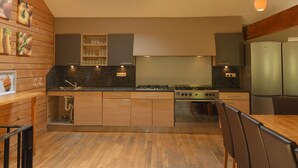 Une cuisine moderne avec des meubles en bois, une cuisinière à gaz et un puits de lumière.