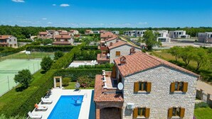 A residential area with stone buildings, a swimming pool, and a tennis court. - Villa Amani Comfortable Holiday Residence (Svetvincenat)