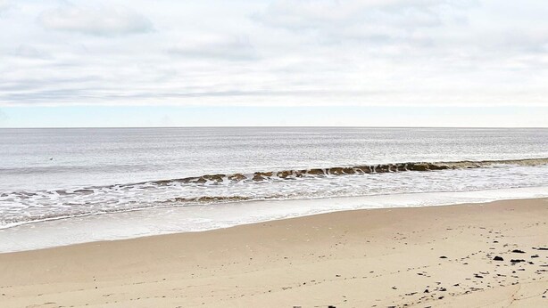 A beach with a calm sea and a cloudy sky. - 7 Person Holiday Home in Yngsjo-by Traum (Yngsjo)