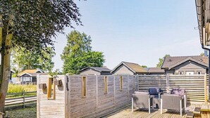 A wooden deck with a fenced area, a table with chairs, and a grill. - 7 Person Holiday Home in Yngsjo-by Traum (Yngsjo)