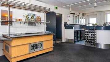A modern kitchen area with a buffet station labeled "BISTRO," a wine rack, and a refrigerator.