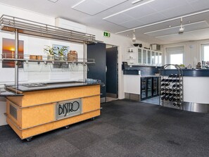 Un espace cuisine moderne comprenant un buffet étiqueté « BISTRO », un meuble à vin et un réfrigérateur.