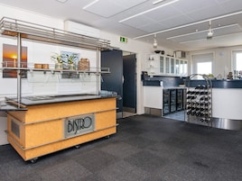Ein moderner Küchenbereich mit einer Buffetauslage mit der Aufschrift 'BISTRO', einem Weinschränkchen und einem Kühlschrank.
