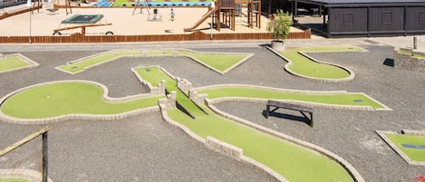 A playground with a sandbox, swings, and a slide.