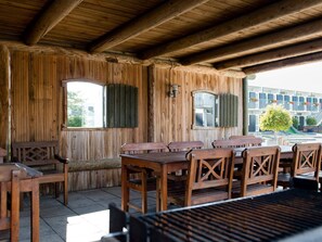Enjoy meals al fresco at this charming outdoor dining area with a long table and comfortable seating.