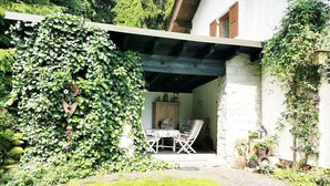 Une maison avec un patio couvert, une table à manger et des chaises.