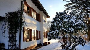 Un bâtiment à deux étages, dont la façade est recouverte de neige et est faite de bois.