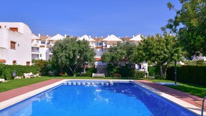 A rectangular swimming pool with a tiled edge, surrounded by a brick walkway. - Belvilla by OYO Torreblanca I Primera Planta (Torreblanca)