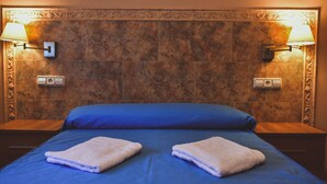 A hotel room with a large bed, two nightstands, and two wall-mounted lamps. - Belvilla by OYO Torreblanca I Primera Planta (Torreblanca)