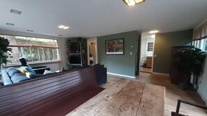 A living room with a wooden bench, a sofa, a TV, and a fireplace. - Holiday Home in Voorthuizen With Hot Tub (Voorthuizen)