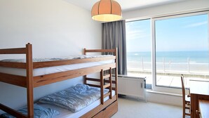 Ein Schlafraum mit Etagenbetten und Blick auf den Strand.