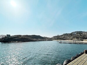 A calm lake with a wooden dock extending into the water, surrounded by hills and a clear sky. - 4 Star Holiday Home in Fagerfjall (Fagerfjäll)