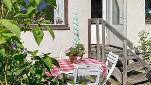 A patio with a red and white checkered tablecloth, white chairs, and a potted plant. - 4 Person Holiday Home in Odsmal (Oedsmal)