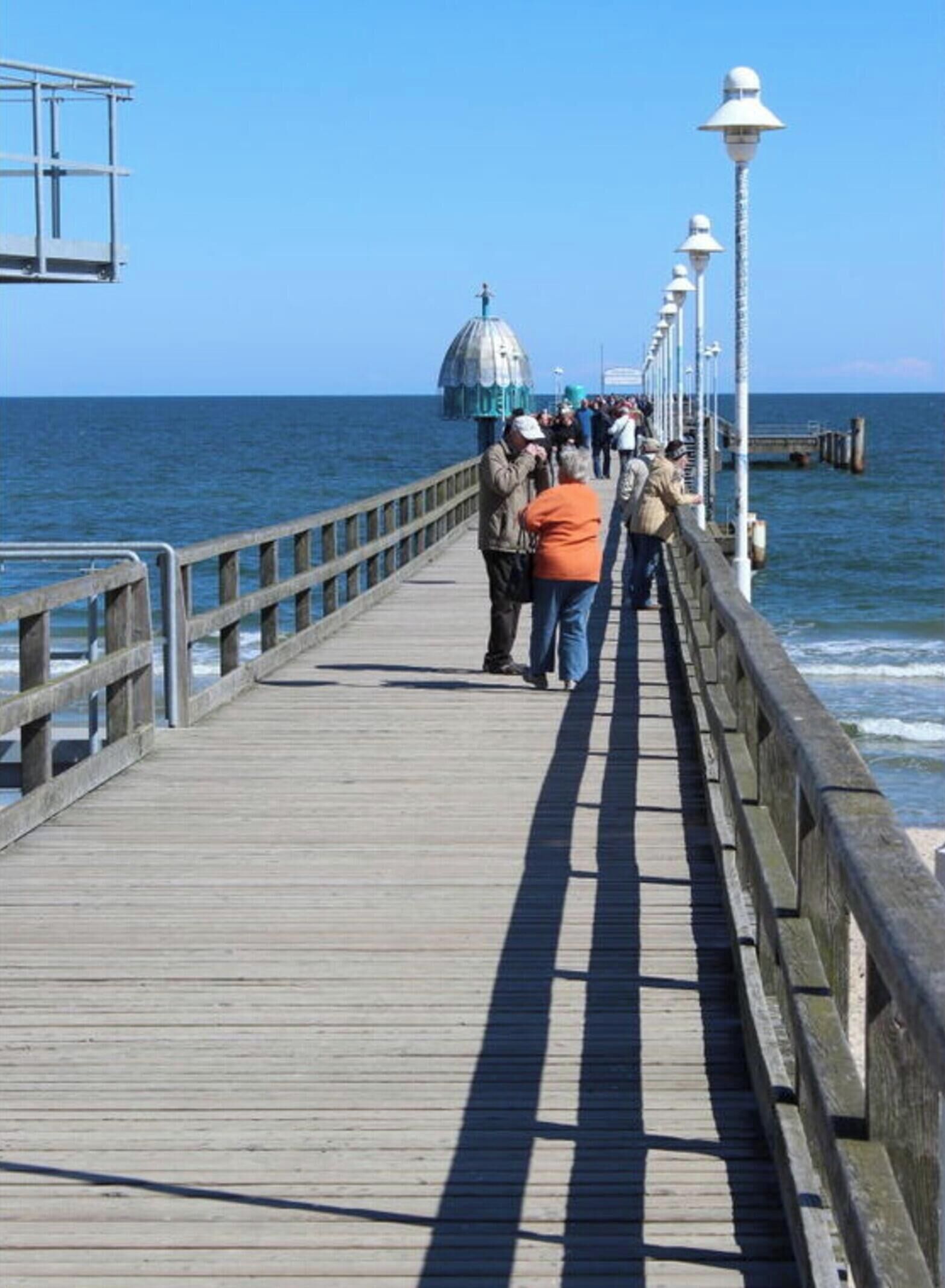 Un muelle de madera que se adentra en el mar bajo un cielo despejado.