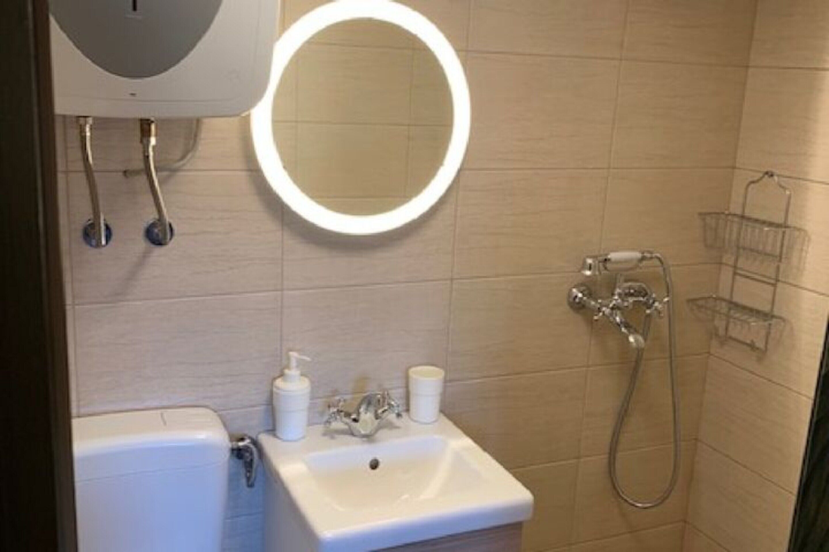 Ein Badezimmer mit Waschbecken, Spiegel und Dusche.