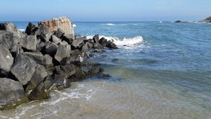 A rocky shoreline with clear blue water and a large rock formation. - 4 Person Holiday Home in Hjorring (Hjørring)