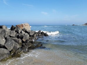 A rocky shoreline with clear blue water and a large rock formation. - 4 Person Holiday Home in Hjorring (Hjørring)