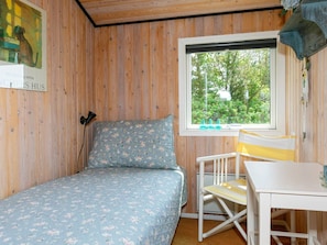 A small room with a bed, a window, a chair, and a table. - 4 Person Holiday Home in Hjorring (Hjørring)
