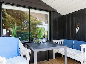 An outdoor seating area with a table, chairs, and a bench. - 4 Person Holiday Home in Hjorring (Hjørring)