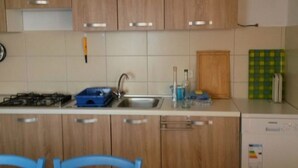 A kitchen with wooden cabinets, a gas stove, a sink, and a dishwasher.