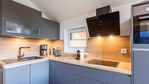 A modern kitchen with grey cabinets, a stainless steel sink, a built-in oven, and a window above the sink. - Amazing Chalet With Terrace (Stadl-Predlitz)