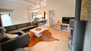 A modern living room with a leather sofa, a wooden coffee table, and a stone wall.
