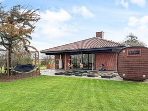A modern house with a tiled roof, a covered patio, and a hammock. - 4 Star Holiday Home in Ulfborg (Ulfborg)