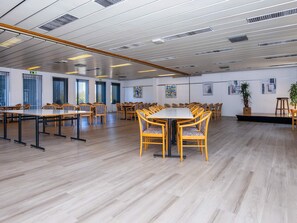 A spacious conference room with multiple tables and chairs, large windows, and artwork on the walls. - 4 Person Holiday Home on Holiday Park in Glesborg (Glesborg)
