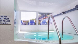 A small indoor pool with a glass wall, a metal ladder, and a sign indicating a 15-minute wait time. - 4 Person Holiday Home on Holiday Park in Glesborg (Glesborg)