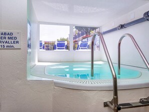A small indoor pool with a glass wall, a metal ladder, and a sign indicating a 15-minute wait time. - 4 Person Holiday Home on Holiday Park in Glesborg (Glesborg)