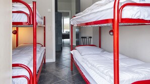 A room with bunk beds, a small table, and a door leading to another room. - 4 Star Holiday Home in Sydals (Sydals)