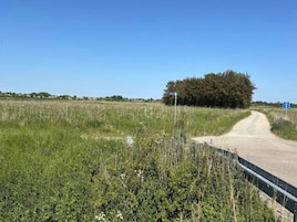Un camino rural con un letrero azul que señala un estacionamiento.