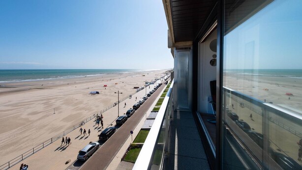 Vistes a la platja des d'un edifici amb un llarg balcó que domina la platja i l'oceà.