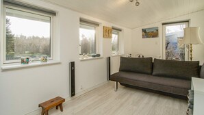 A room with a sofa, a bench, and a window with a view of trees. - 4 Person Holiday Home in Grevinge (Grevinge)