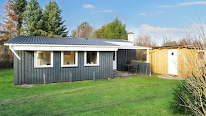 A single-story house with a dark exterior, a tiled roof, and a small attached garage. - 4 Person Holiday Home in Grevinge (Grevinge)