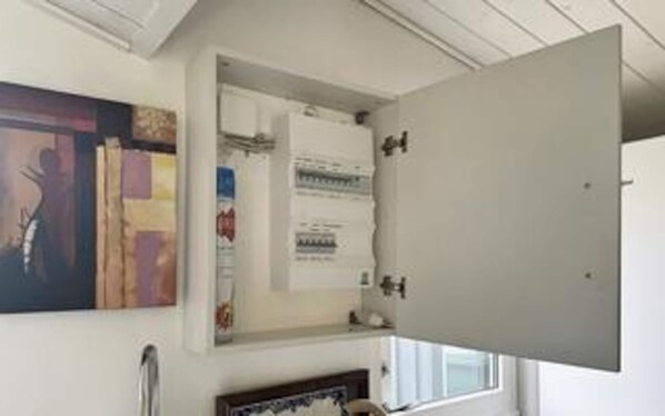 Une pièce avec une grande porte ouverte, une fenêtre et une œuvre d’art accrochée au mur.