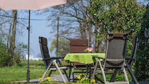 An outdoor seating area with two chairs and a table, surrounded by greenery and a clear sky. - Lovely Apartment in Straelen (Straelen)