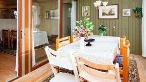 A dining area with a table, chairs, and a vase of flowers. - 8 Person Holiday Home in Farvang (Farvang)