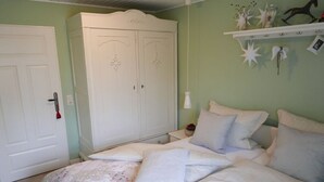 Une chambre à coucher comprenant un lit, une armoire et une étagère avec des objets décoratifs.